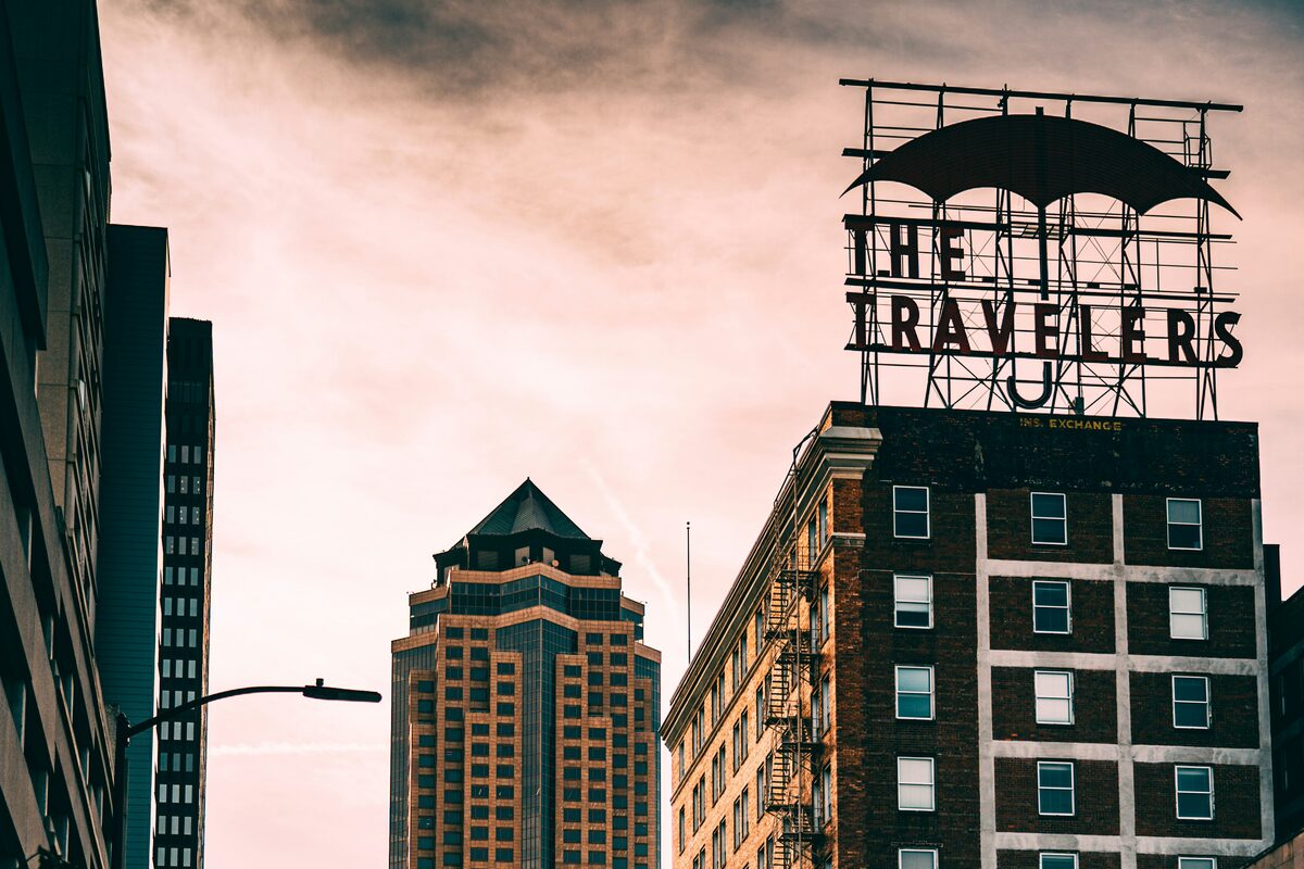 Downtown Des Moines, Iowa high-rises at dusk, including the historic Travelers umbrella sign atop the Insurance Exchange Building