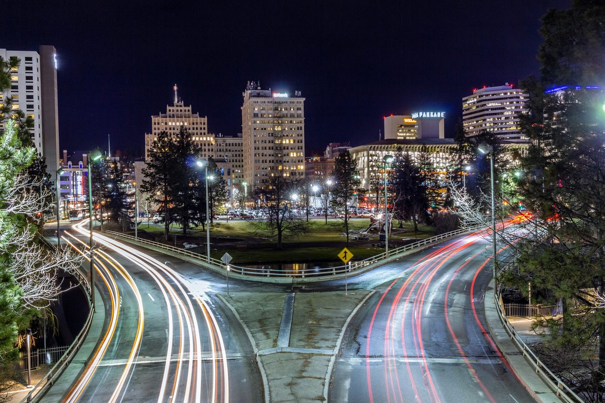 Downtown Spokane, Washington at night with light trails on the roads leading toward the skyline