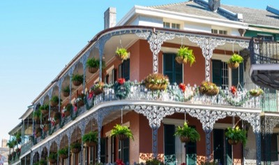 Ornate cast-iron galleries with hanging ferns on a French Quarter building in New Orleans