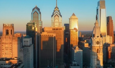 Center City Philadelphia at golden hour, with the clock tower and William Penn statue of City Hall in front of Liberty Place and the Comcast Center