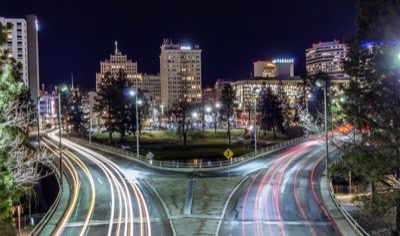 Downtown Spokane, Washington at night with light trails on the roads leading toward the skyline